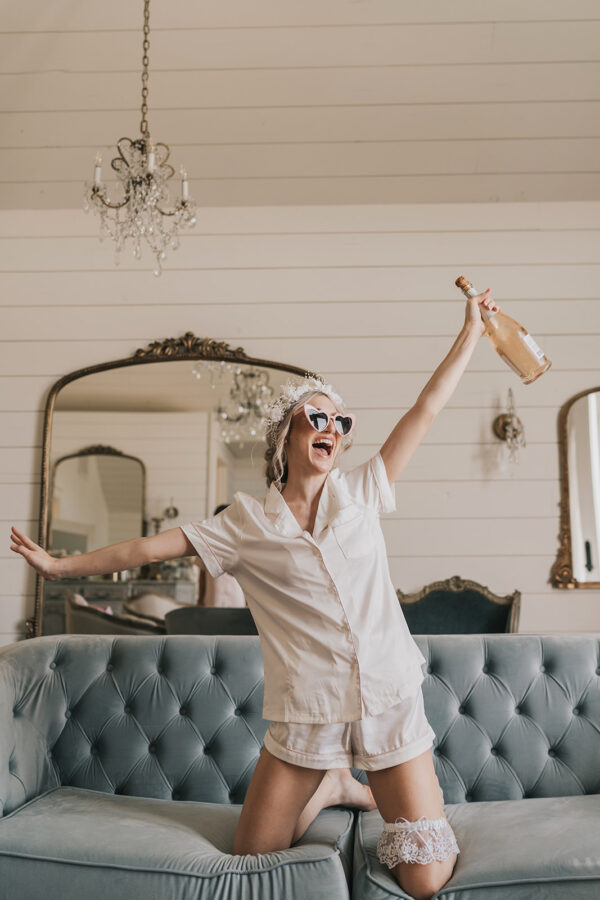 excited bride poses in French Farmhouse bridal suite