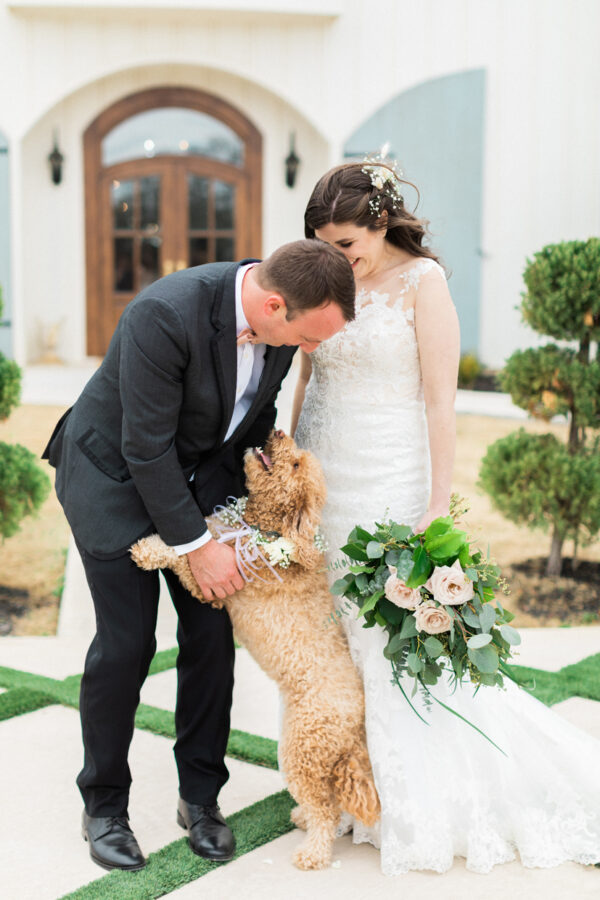 couple poses with their dog after their first look