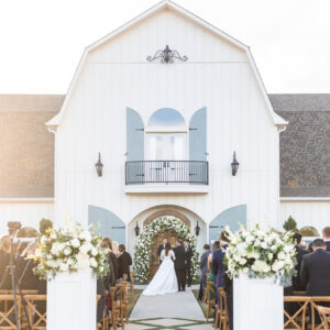 The French Farmhouse wedding venue with a ceremony taking place in front.