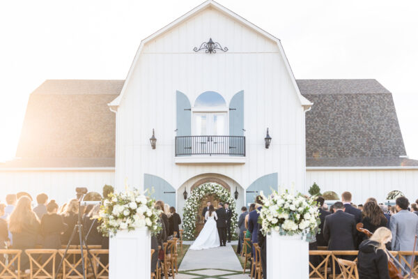 The French Farmhouse wedding venue with a ceremony taking place in front.