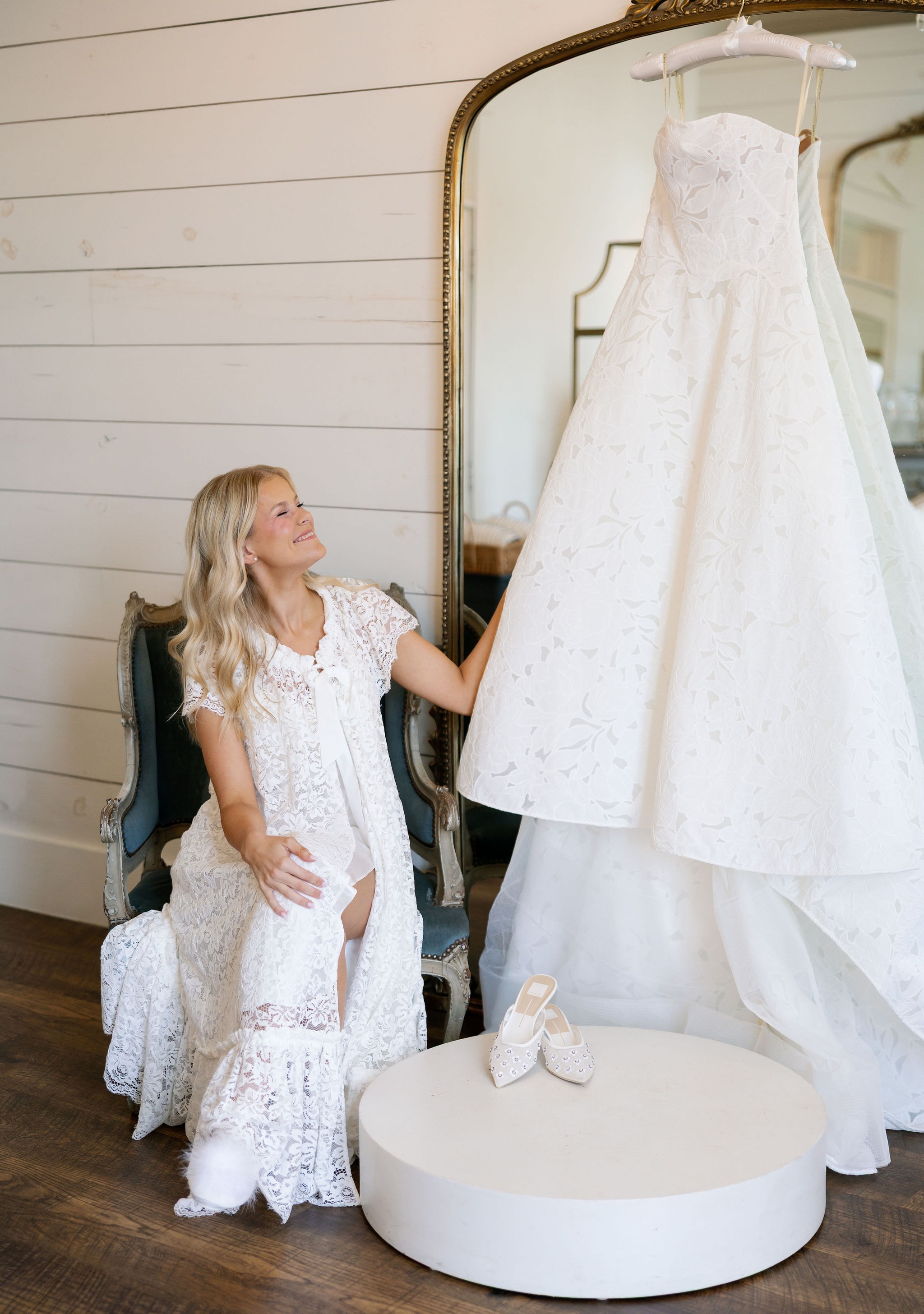 Bride admiring her wedding gown hanging in the bridal suite