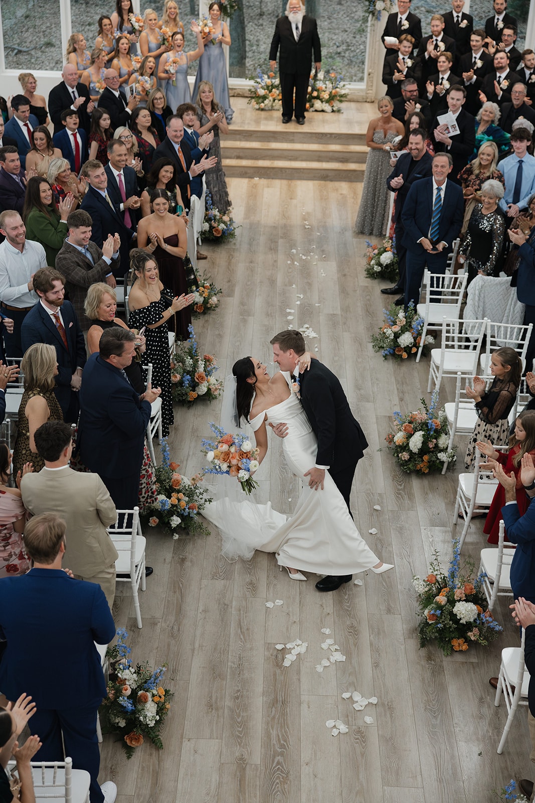 Aerial view of Avery and Pearson dipping and kissing during their recessional as guests cheer