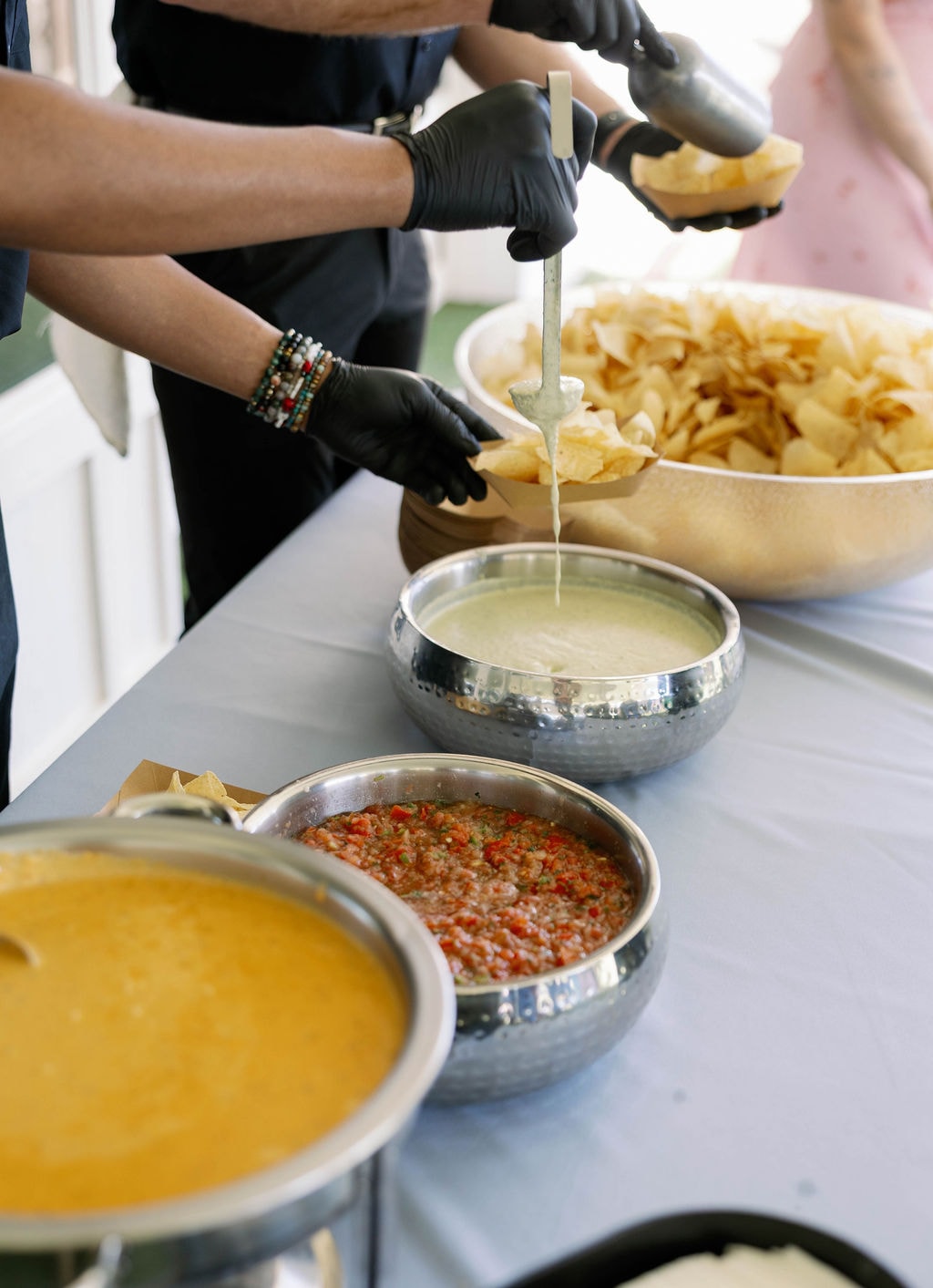 Chuy's chips, queso, and salsa being served at a wedding reception