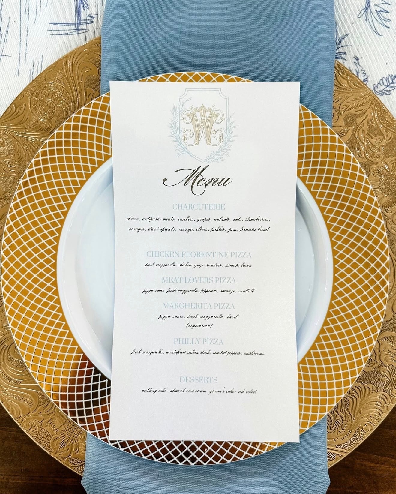 Elegant wedding menu card on a gold charger plate showing Fireova pizza options