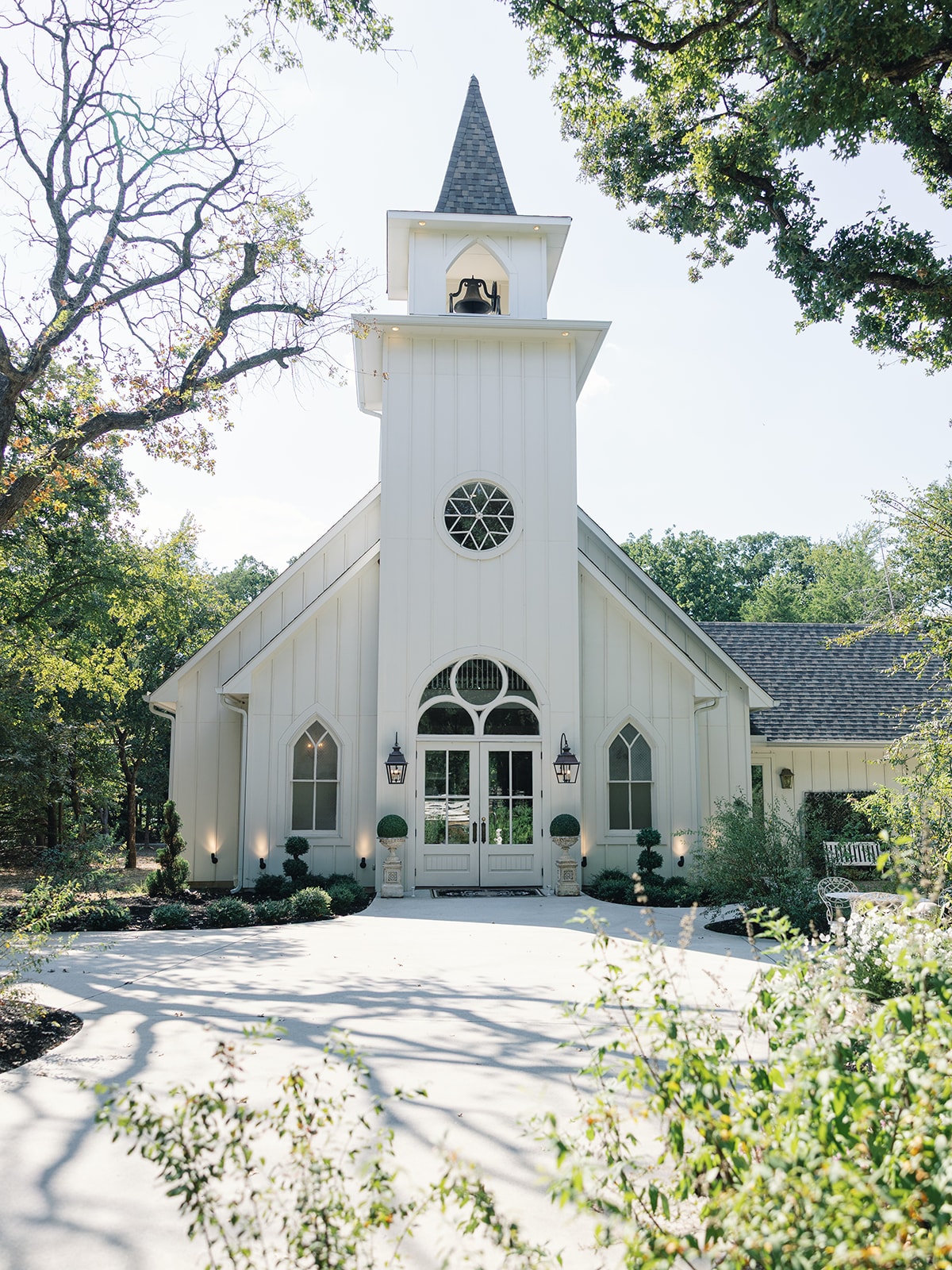 Chapel interior set for Corynn and CJ's ceremony with blue and white floral arrangements lining the aisle and a floral arch at the altar