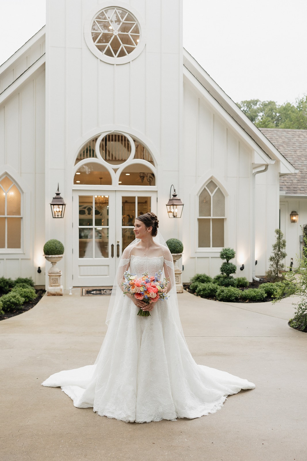 Elizabeth standing in front of the chapel in her wedding gown