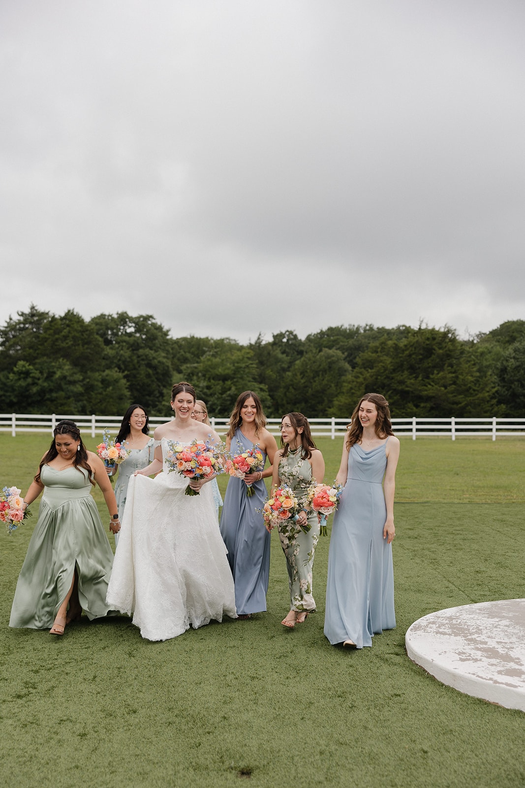 Bridesmaids walking across the grounds with colorful bouquets