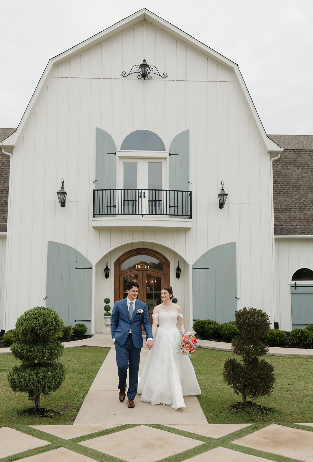 Elizabeth and Nathan walking hand in hand in front of the venue