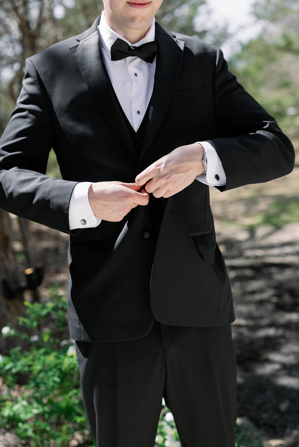 Jake buttoning his tuxedo jacket outdoors on the morning of his wedding