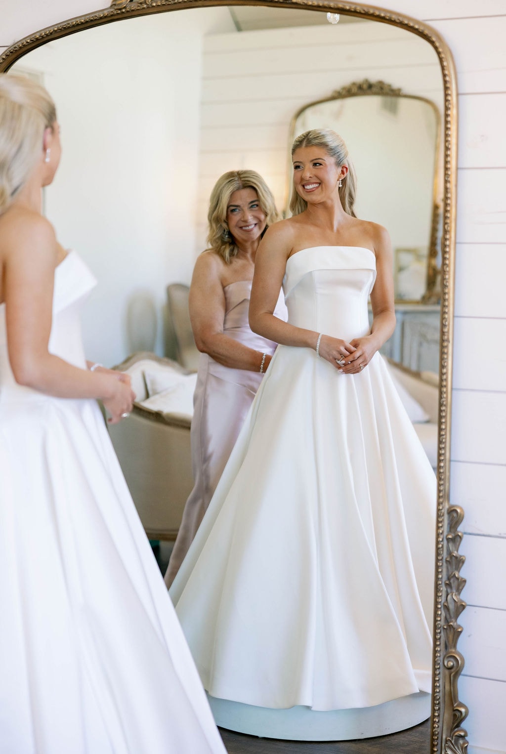 Janie and her mom reflected in the gold antique mirror in the bridal suite