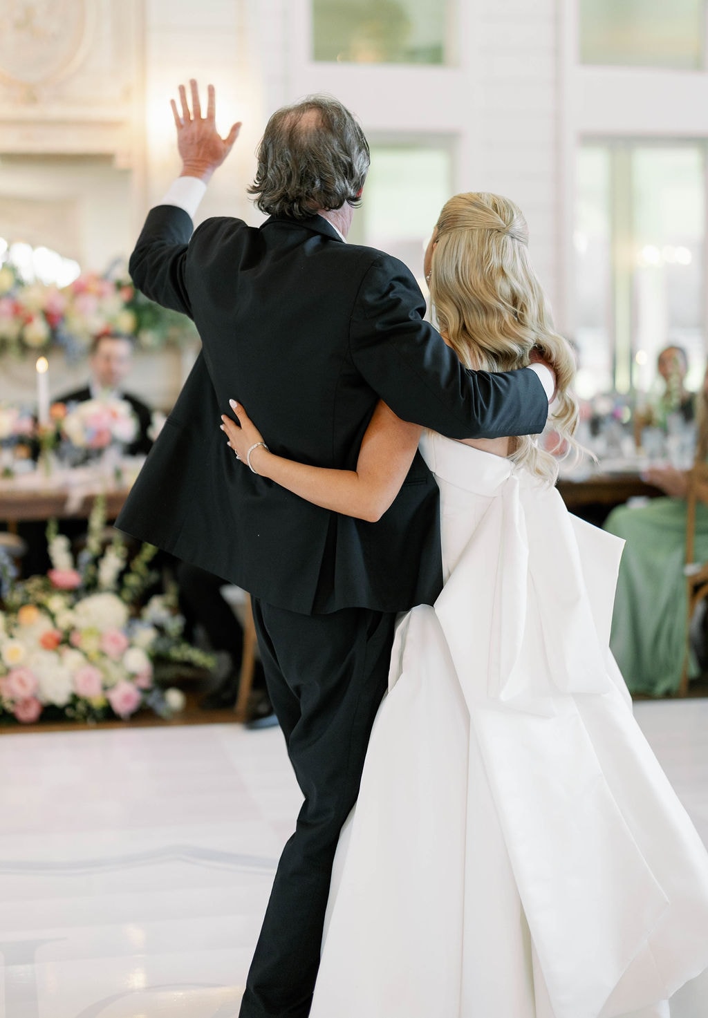 Janie dancing with her father, his hand raised, during the father-daughter dance