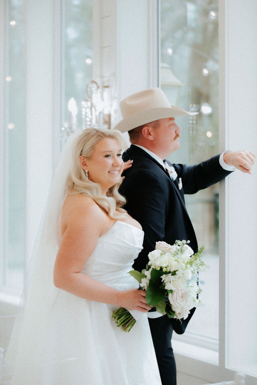 Kara and Anthony sharing a quiet first look moment by the large windows inside the venue