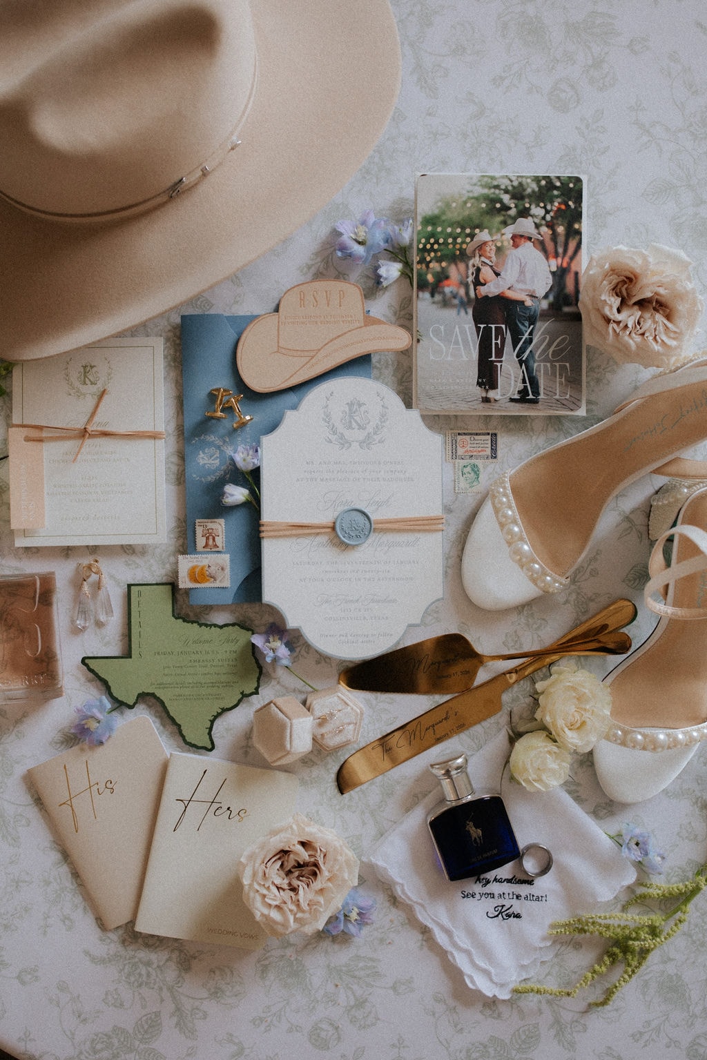 Kara and Anthony wedding stationery flat lay with invitations, save the date, cowboy hat RSVP, pearl heels, and bridal accessories