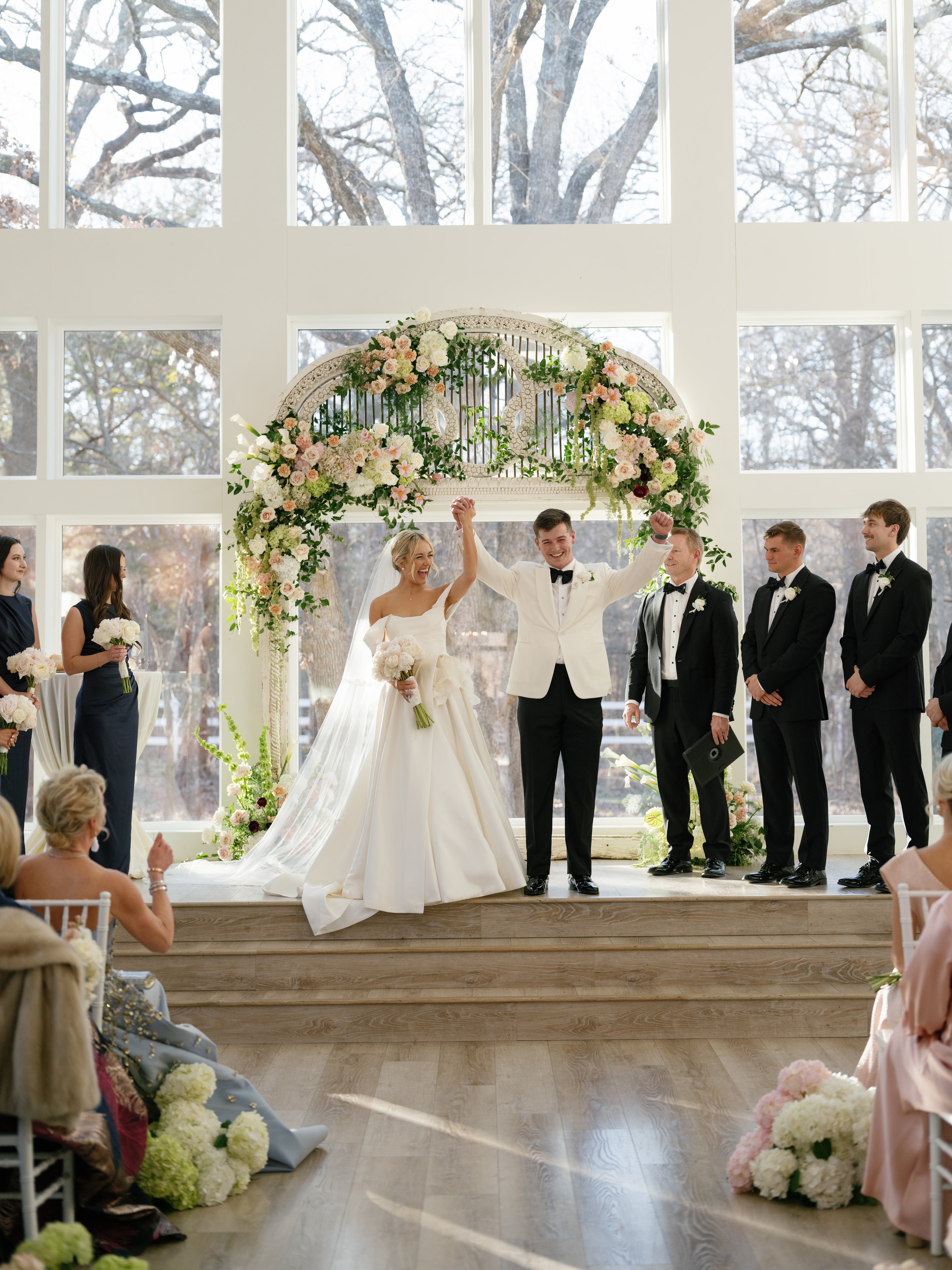 Megan and Rex raising hands just married at the altar inside The French Farmhouse chapel