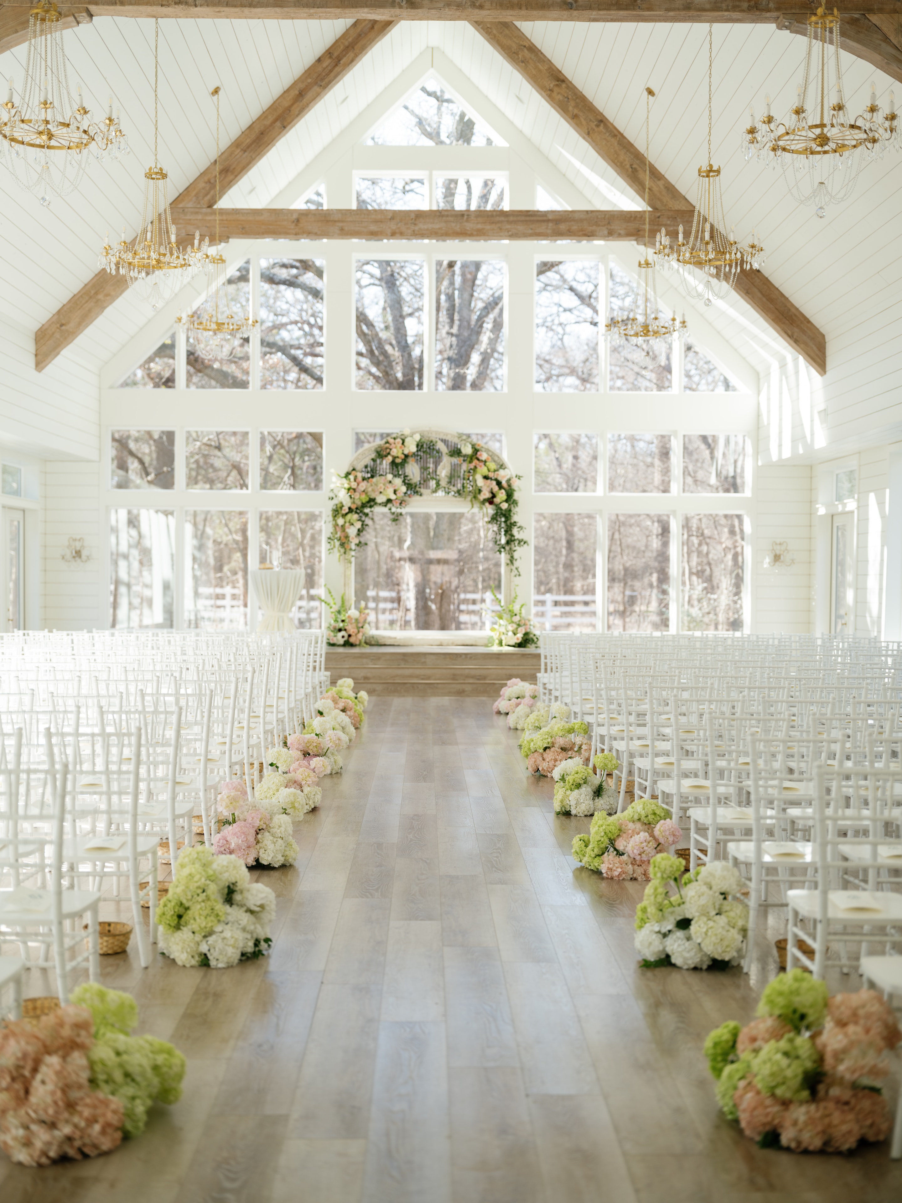 French Farmhouse chapel ceremony setup with hydrangea aisle flowers and floral arch
