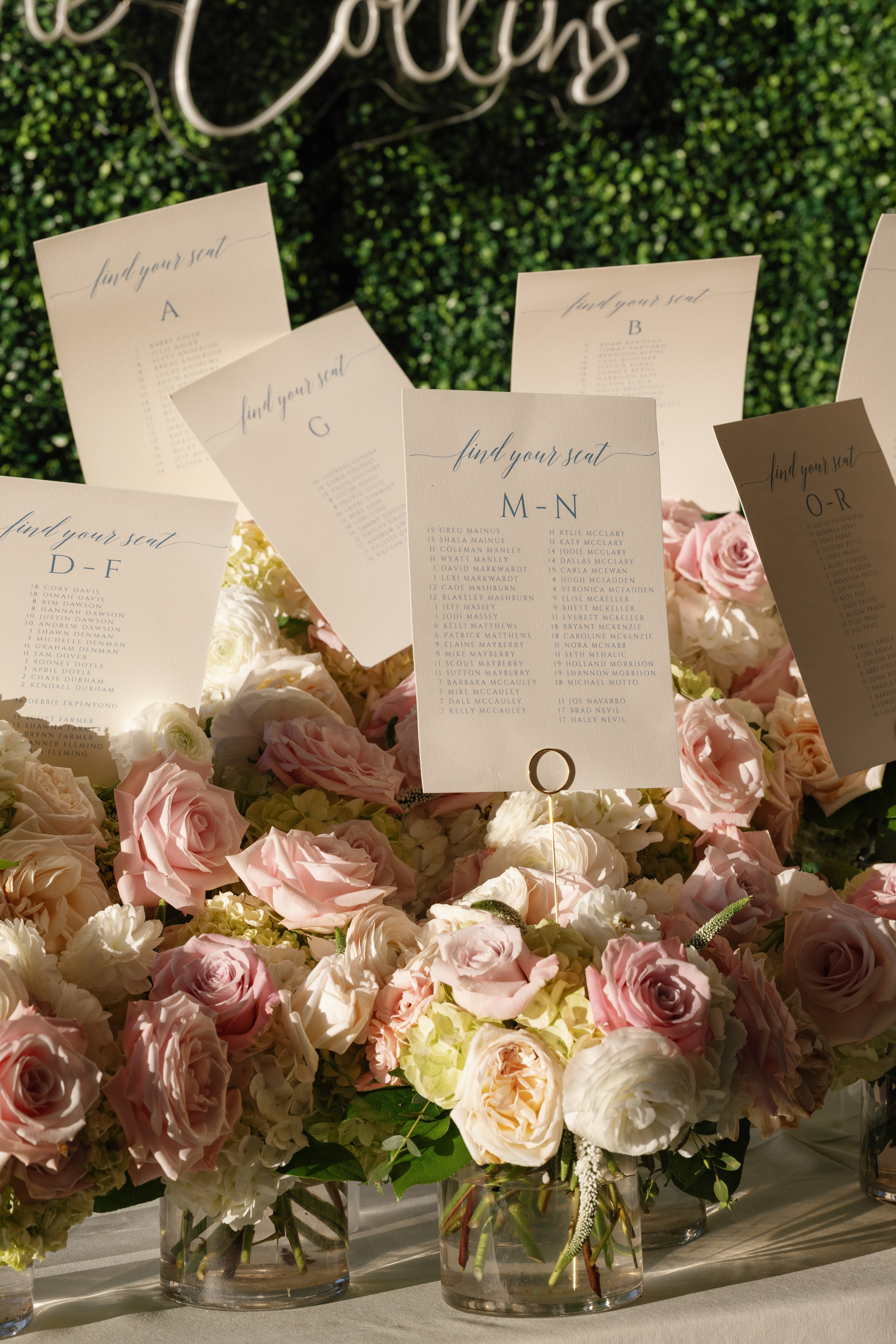 Megan and Rex seating chart cards nestled in pink roses at The French Farmhouse Venue