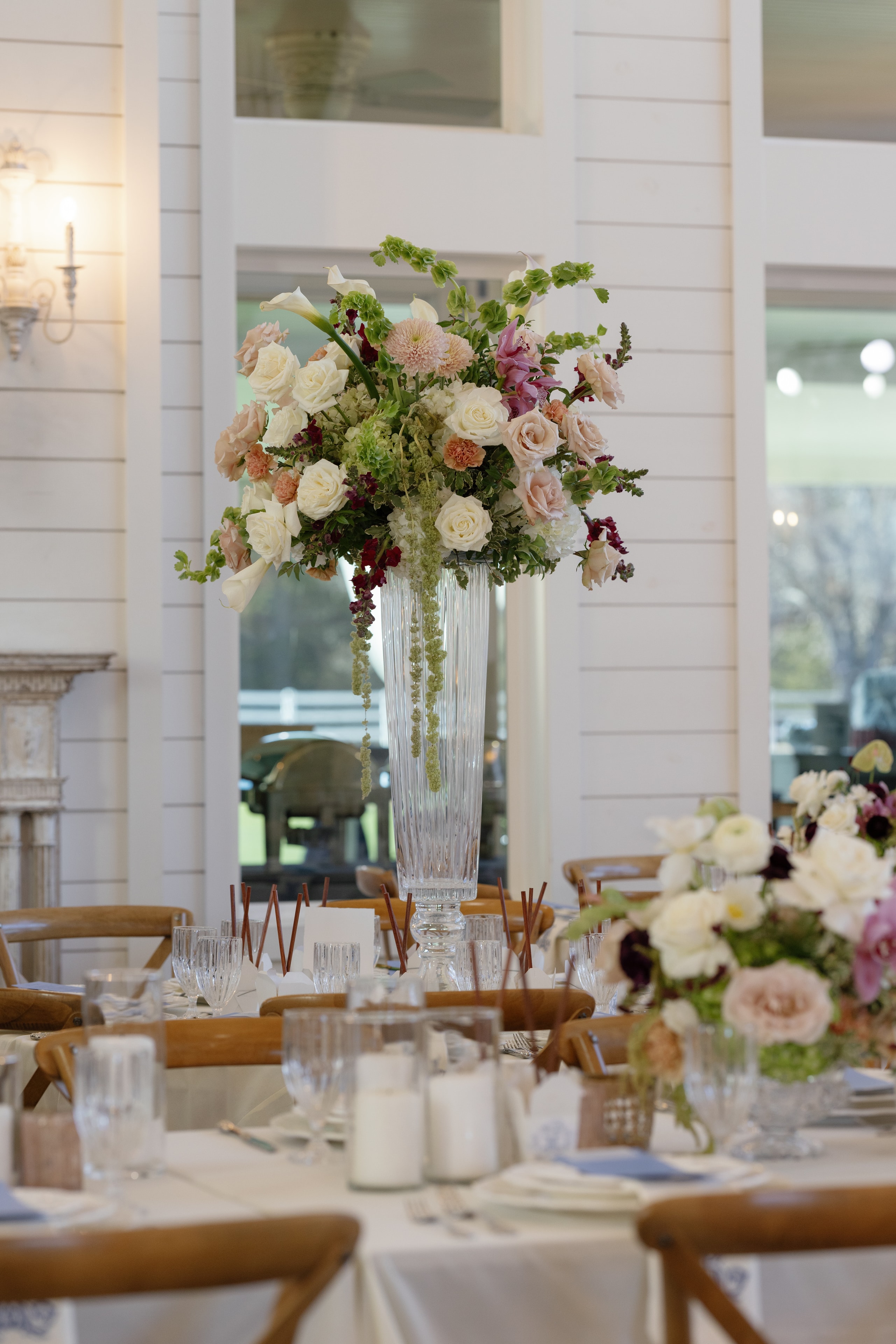 Tall blush and cream floral centerpiece in a crystal vase at the Megan and Rex reception