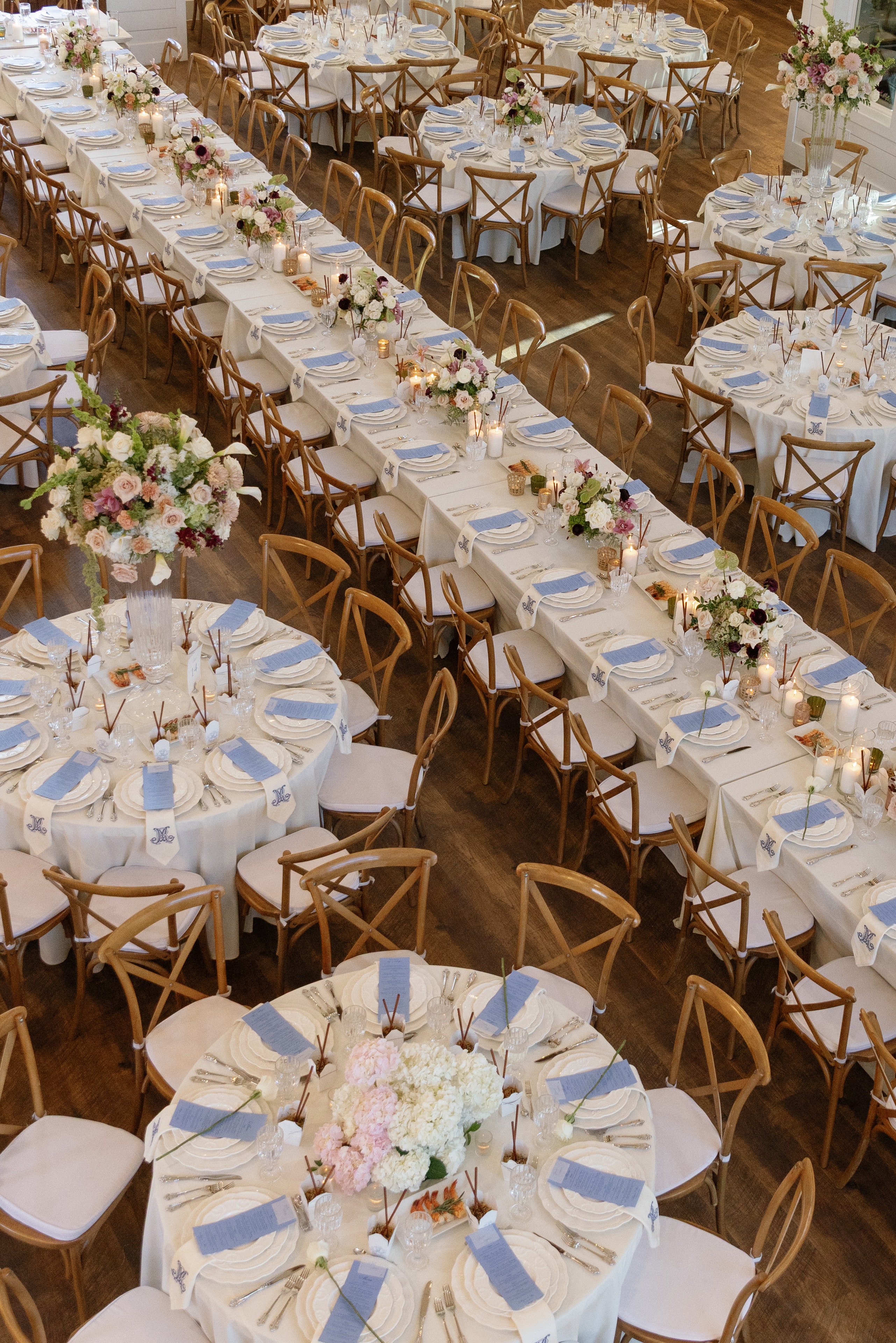 Aerial view of the French Farmhouse reception hall with mixed round and long tables and floral centerpieces