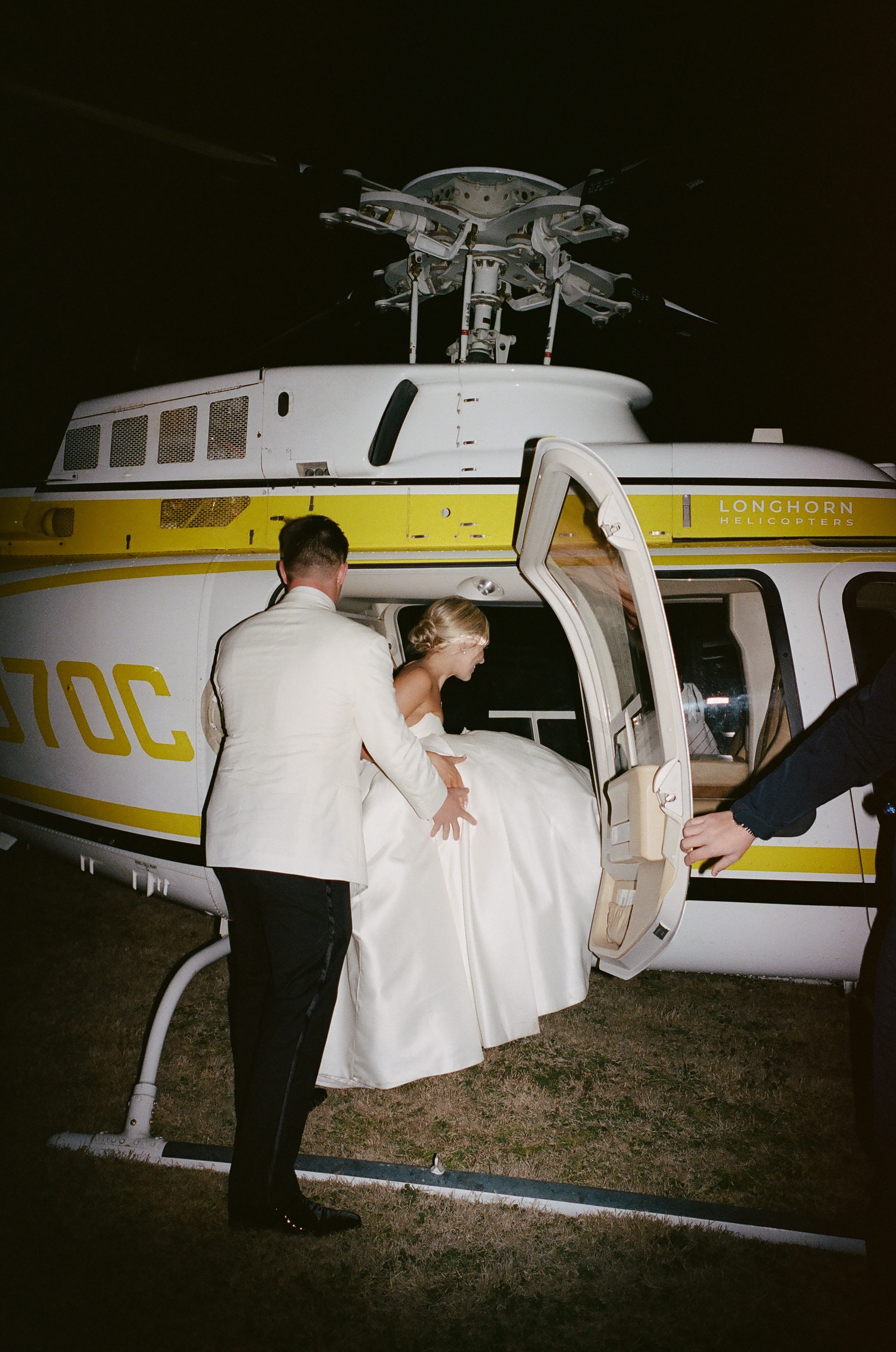 Rex helping Megan board a Longhorn Helicopters helicopter for their wedding send-off