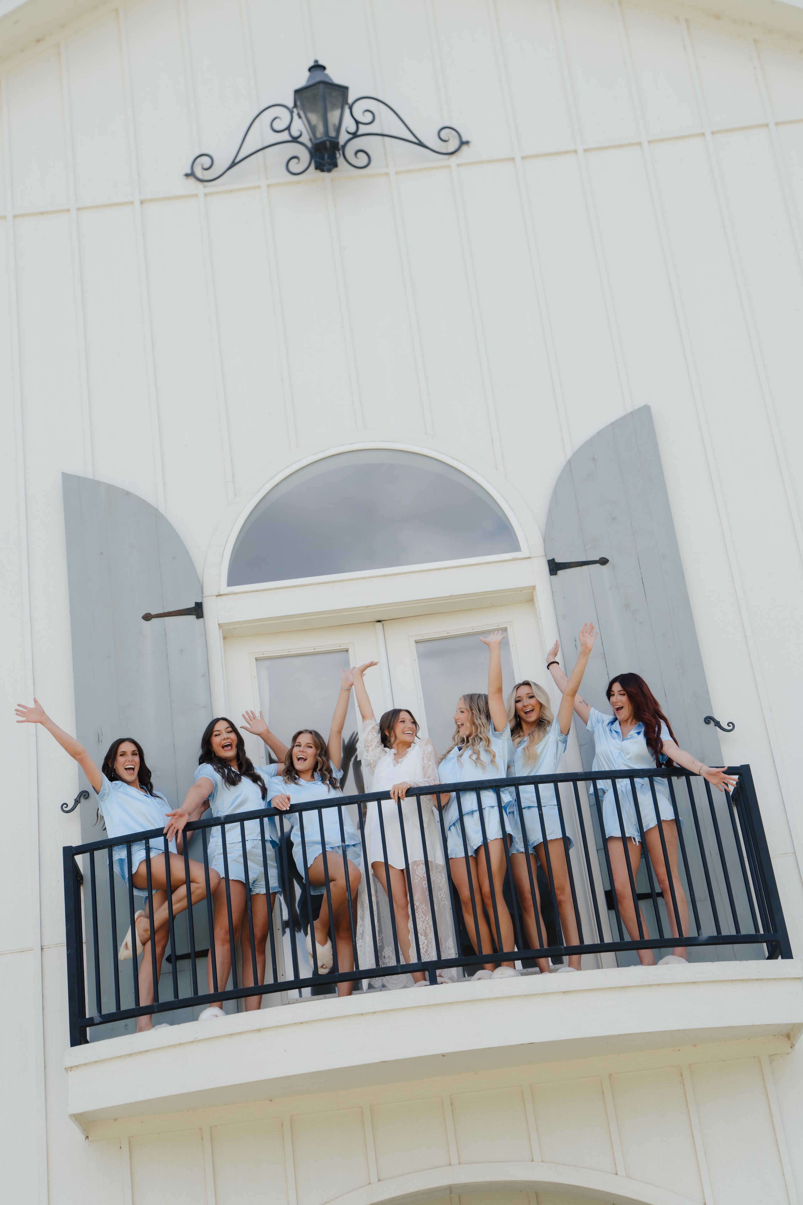 Bridesmaids cheering on the balcony of The French Farmhouse Venue on Paige and DJ's wedding morning