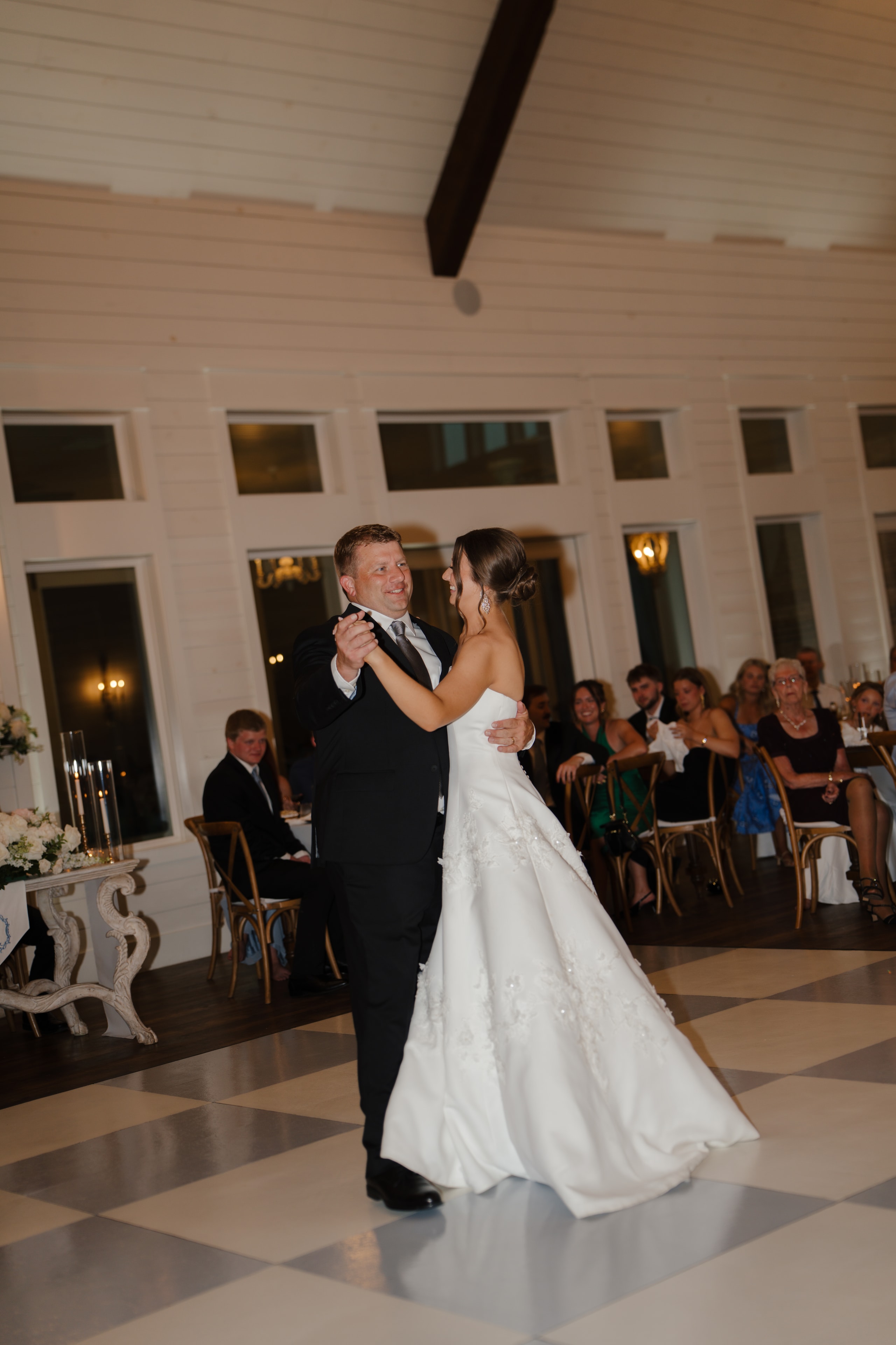 Paige dancing with her father on the checkered dance floor during the father-daughter dance at The French Farmhouse Venue reception