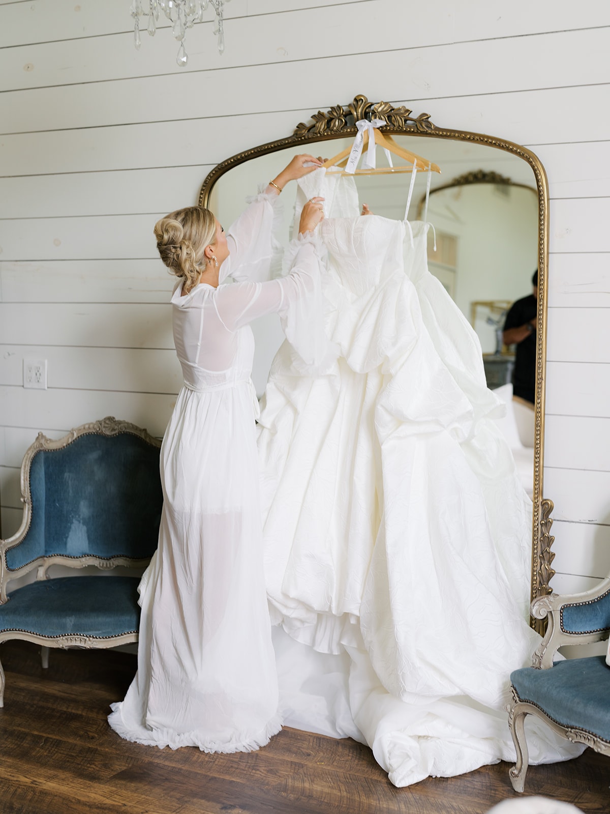 Bride with arms raised on the balcony overlooking the venue grounds