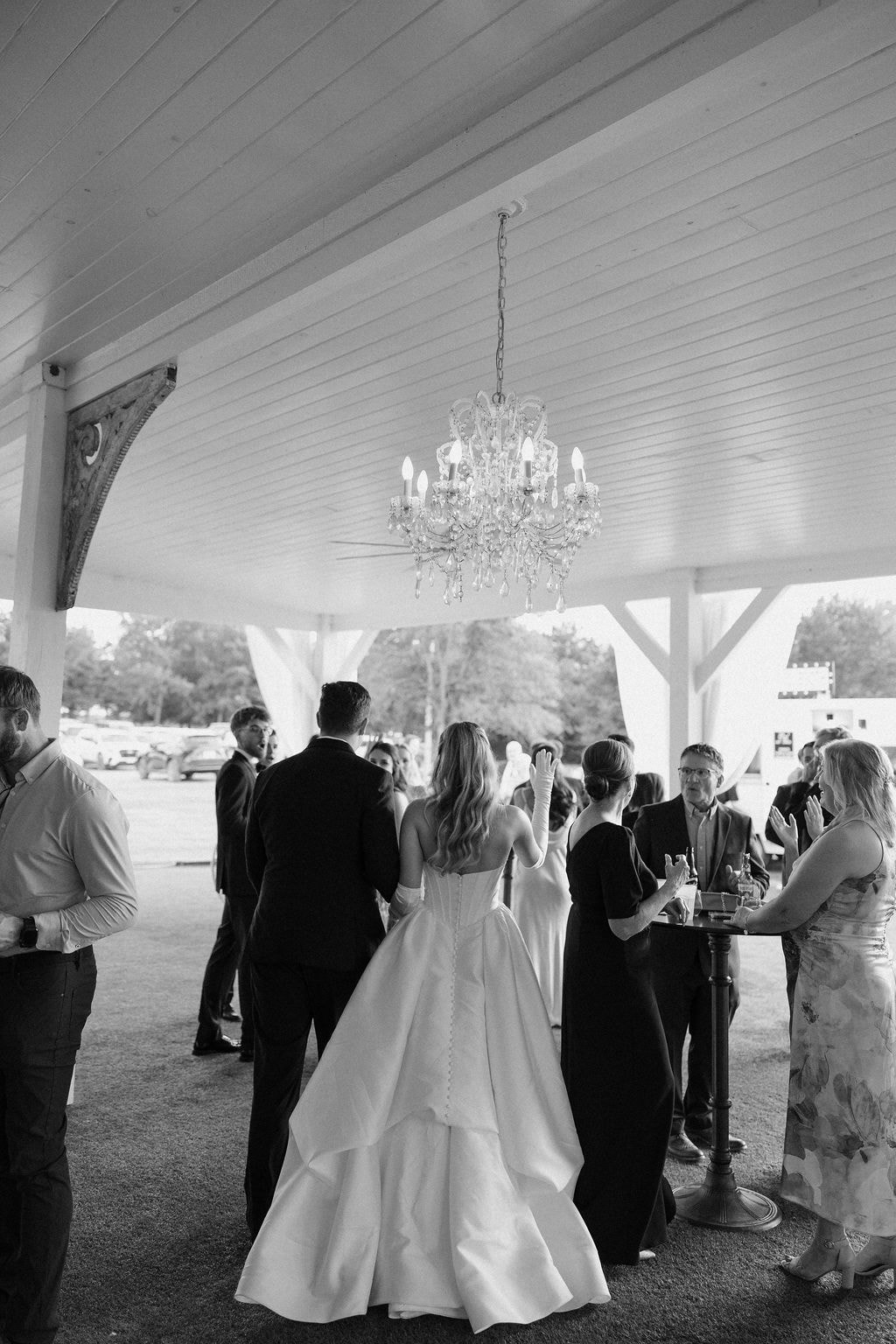 Guests gathered around the decorative fountain during cocktail hour with the venue in the background