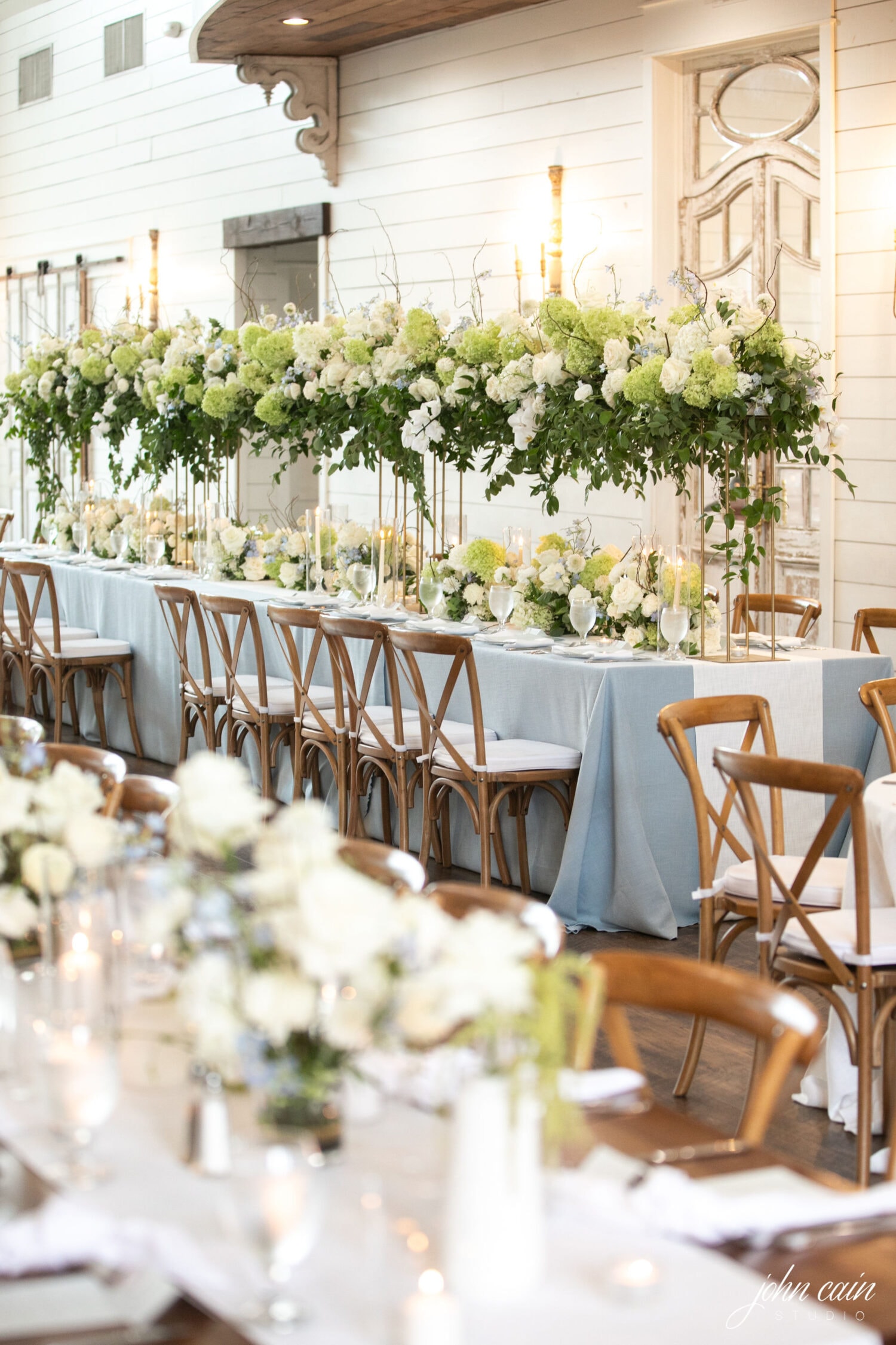 Elegant reception setup at The French Farmhouse Venue with floral centerpieces and table settings for Kylee and Connor's wedding