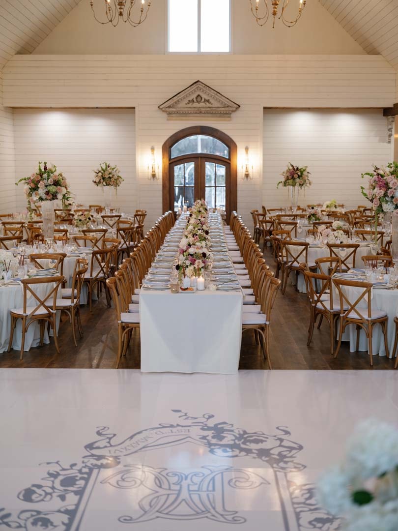 Elegant reception hall at The French Farmhouse Venue with decorated farm tables and colorful floral centerpieces for Kylee and Connor's wedding
