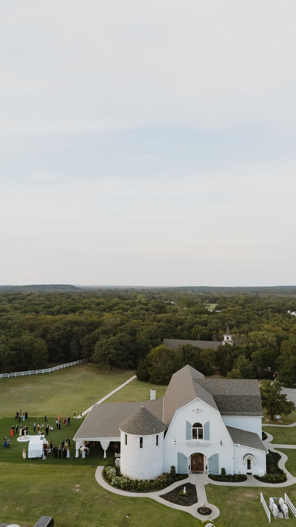 Aerial drone view of The French Farmhouse Venue showing the reception hall, chapel, and surrounding grounds