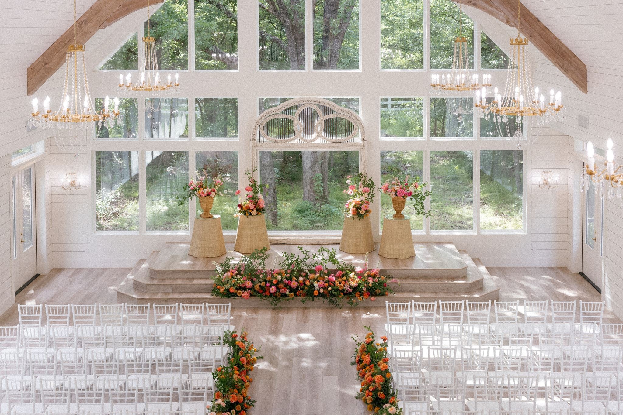 Elegant chapel interior at The French Farmhouse Venue with colorful floral arrangements and chandeliers