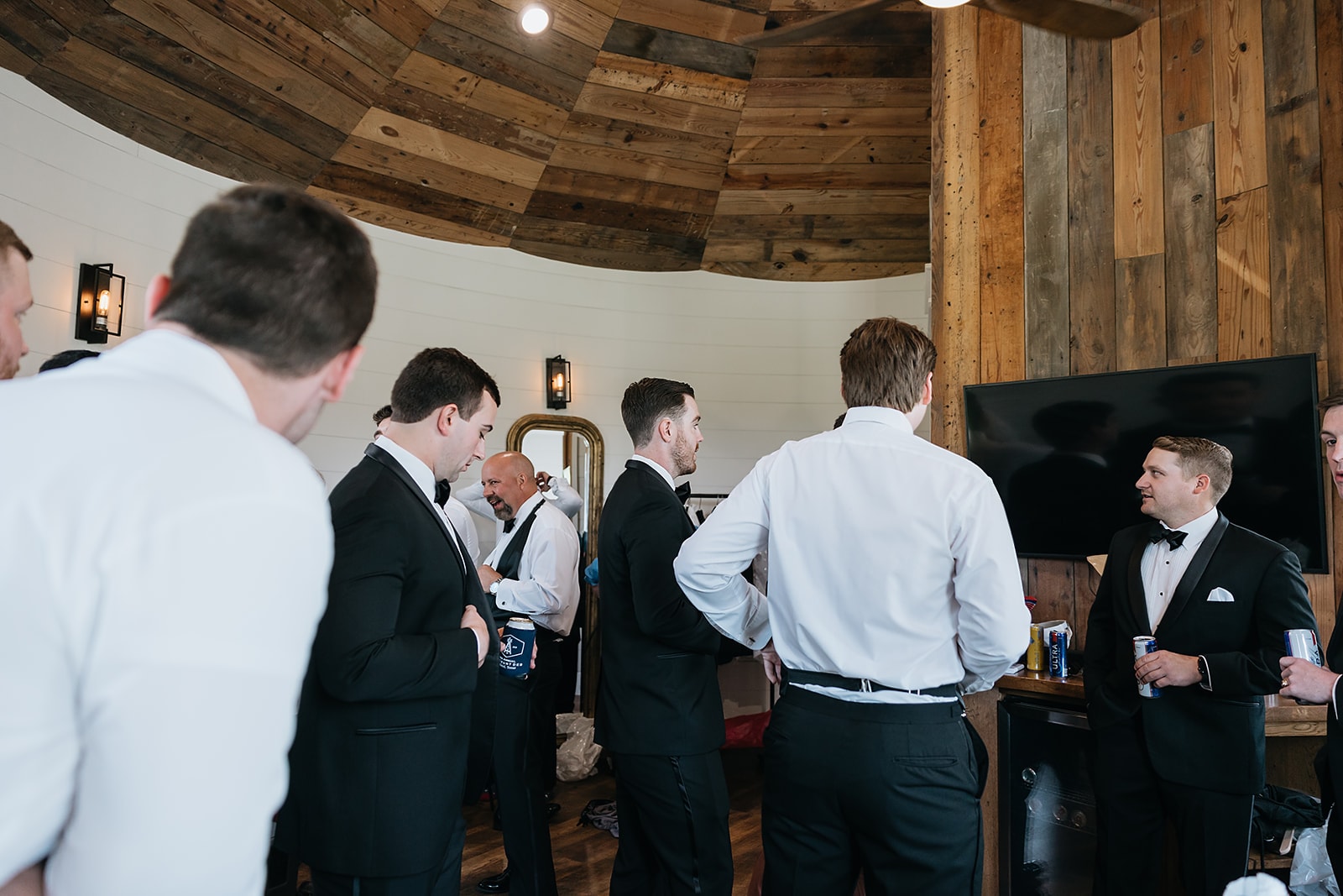 Groomsmen in tuxedos getting ready together in the Groom's Room