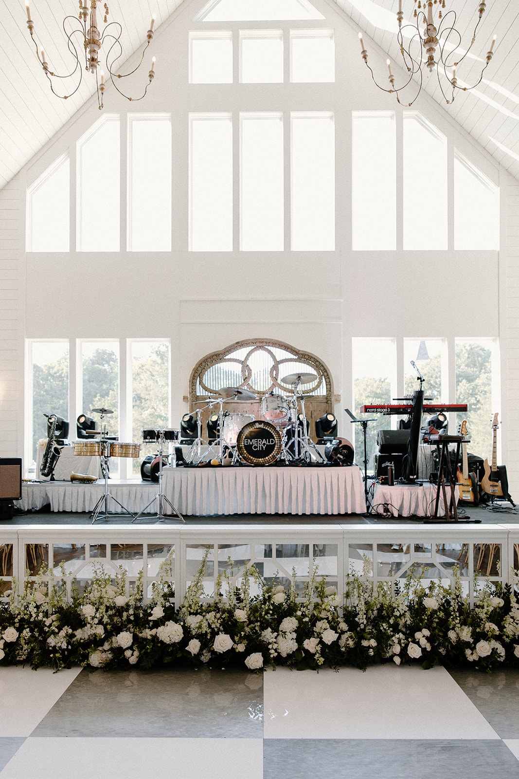 Bride and groom first dance on checkered dance floor with cheering guests at The French Farmhouse Venue